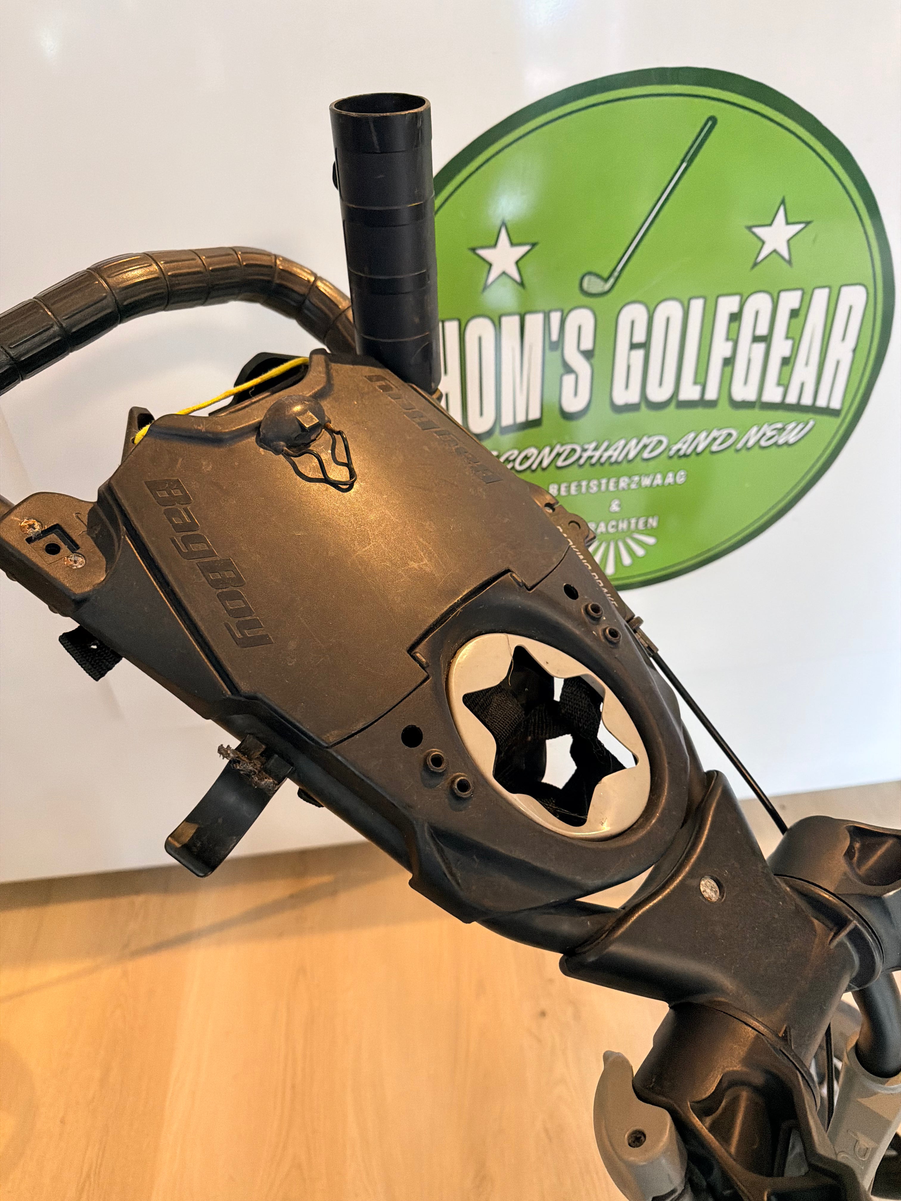 Thom's Golfgear Bagboy Smartquad trolley met vier wielen en handvat, geschikt voor golfclubs, op een groene golfbaan.