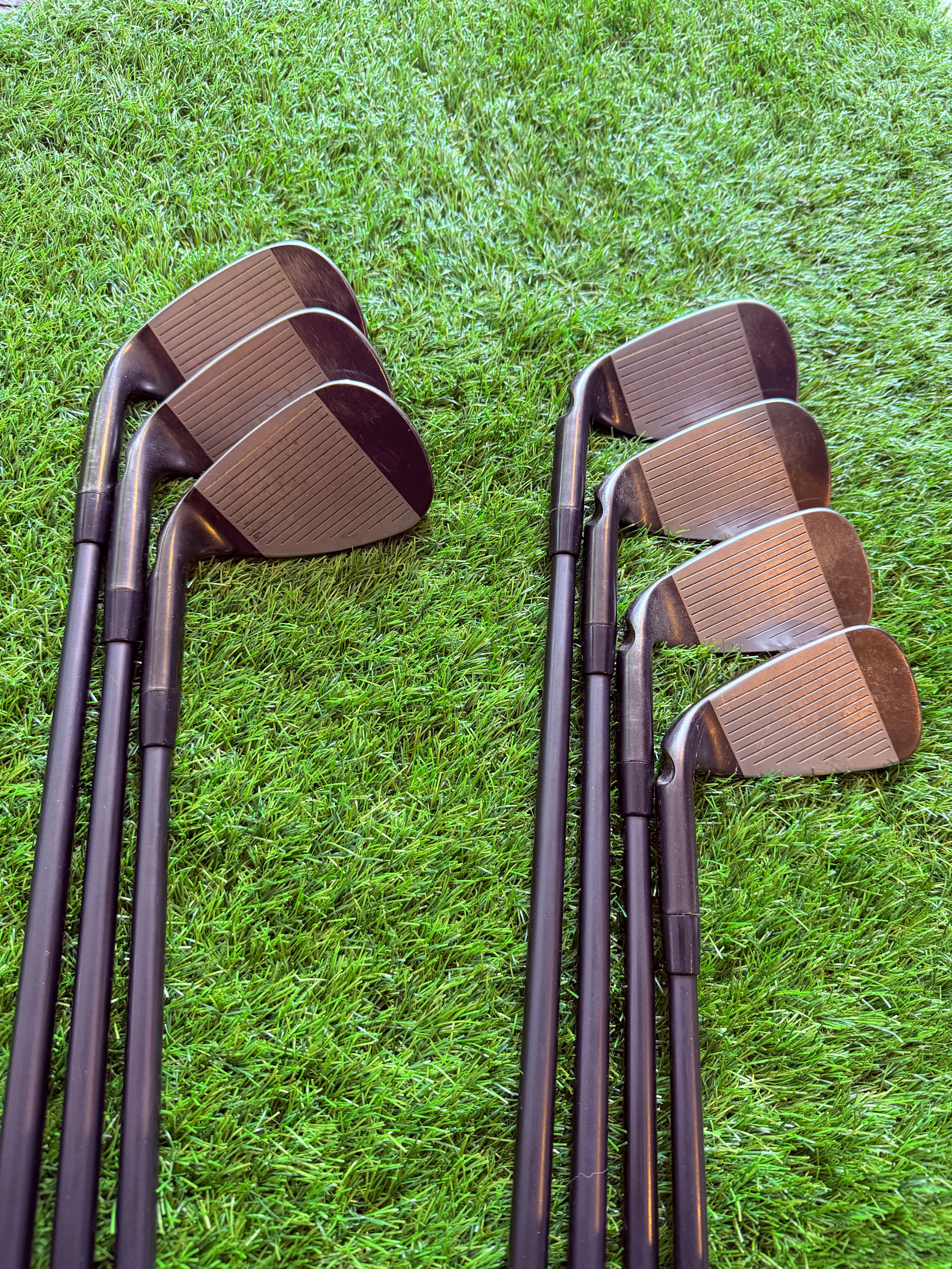 Rechtshandig PING G710 ijzerset 6 tot SW met zwarte stip, golfclubs van Thom's Golfgear, liggend op een golfbaan.