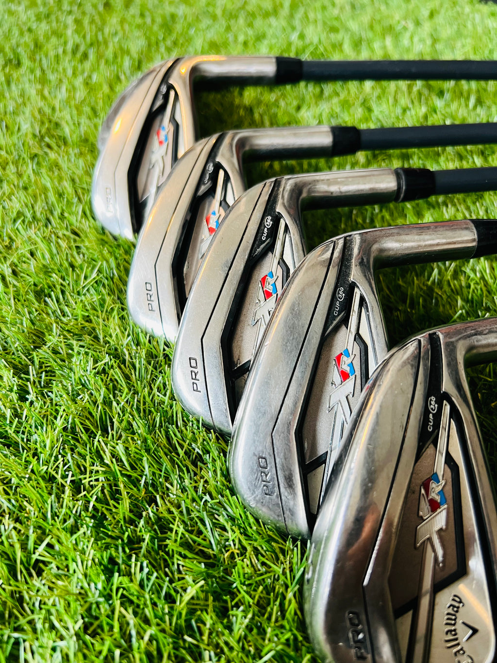 Rechtshandige Callaway XR Pro Cup 360 ijzers 5 tot PW met houten handgreep, golfclubs op scherp en gedetailleerd in close-up.