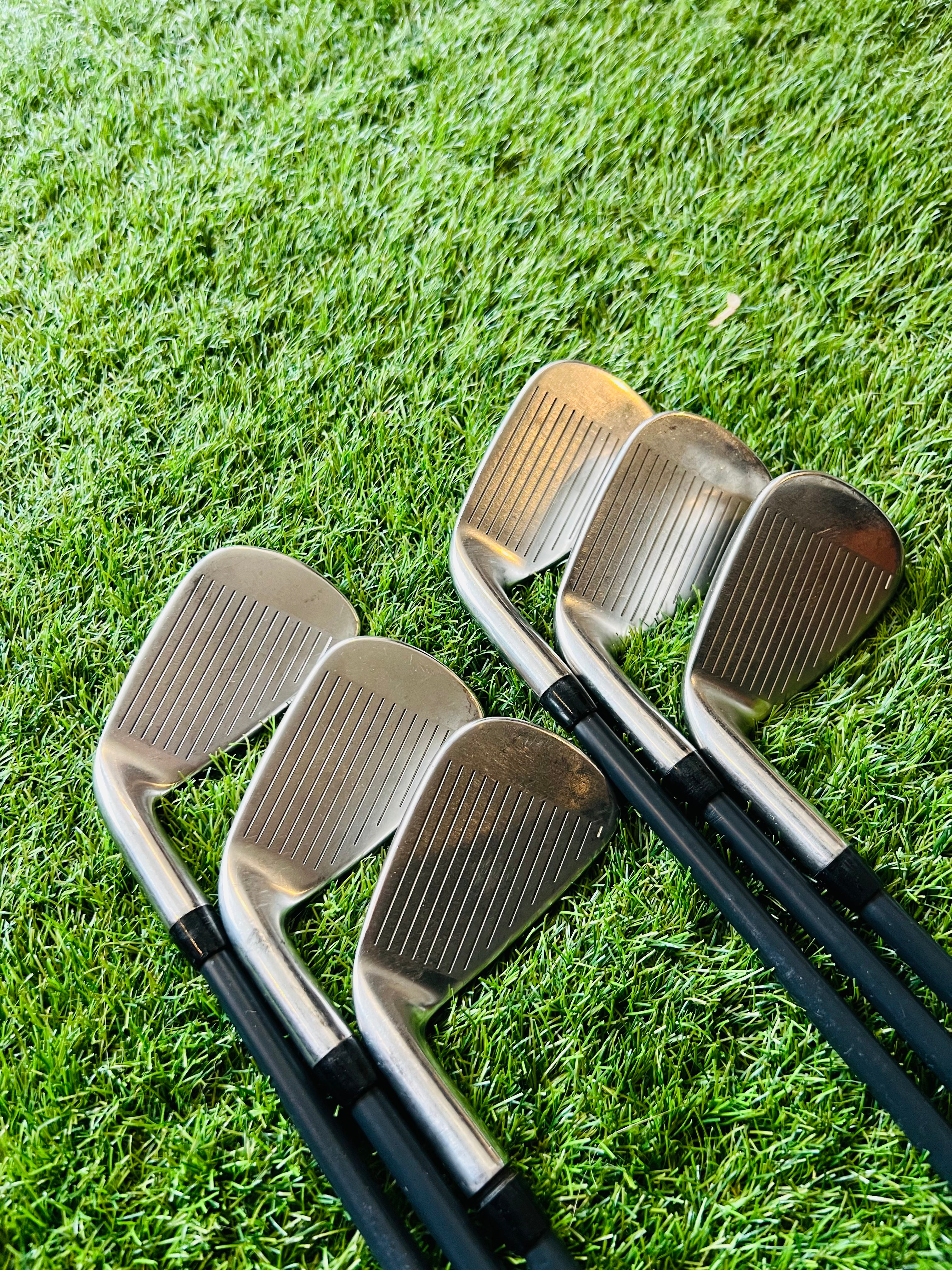 Rechtshandige Callaway XR Pro Cup 360 ijzers 5 tot PW, golfclubs met zwarte grip en clubhoofden op een golfbaan.