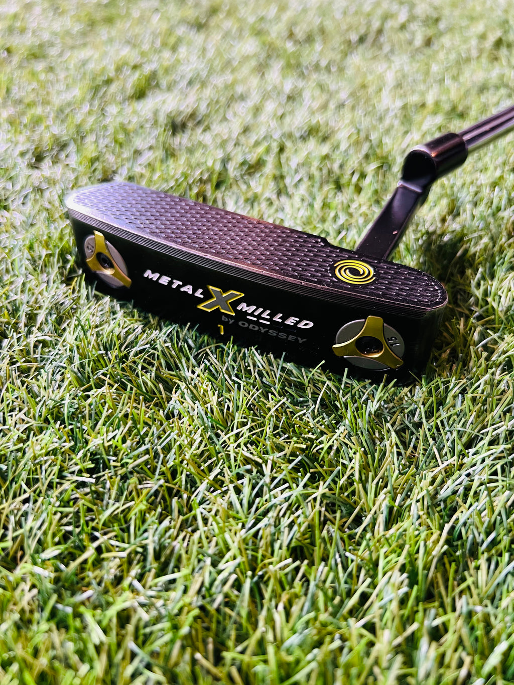 Thom's Golfgear Odyssey Metal-X Milled #1 putter, 34 inch rechtshandig, close-up van de metalen kop en grip op de golfbaan.