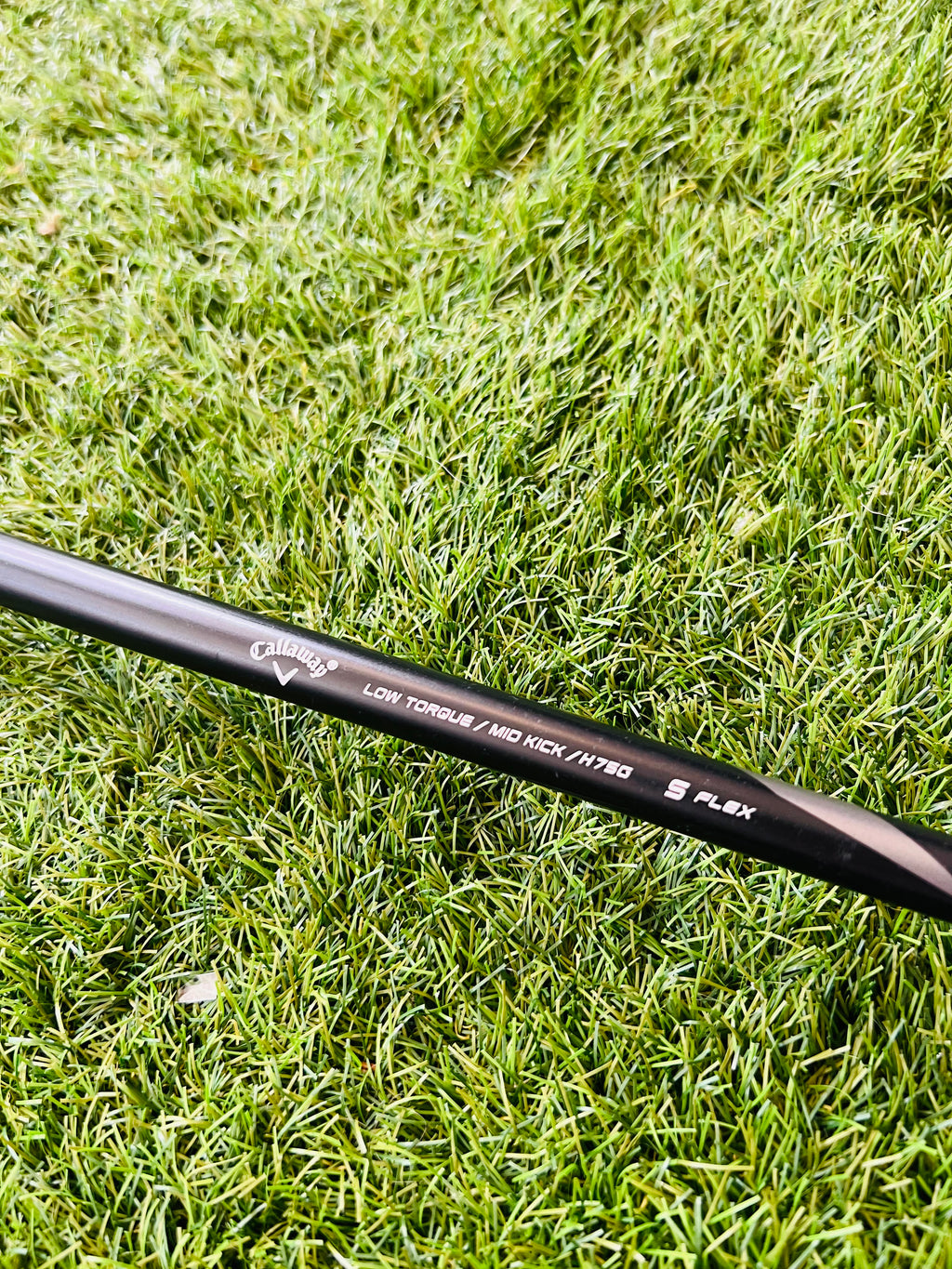 Rechtshandige Callaway RAZR X Tour hybride 2 (18°) golfclub met zwarte grip en titanium clubhoofd op golfbaan