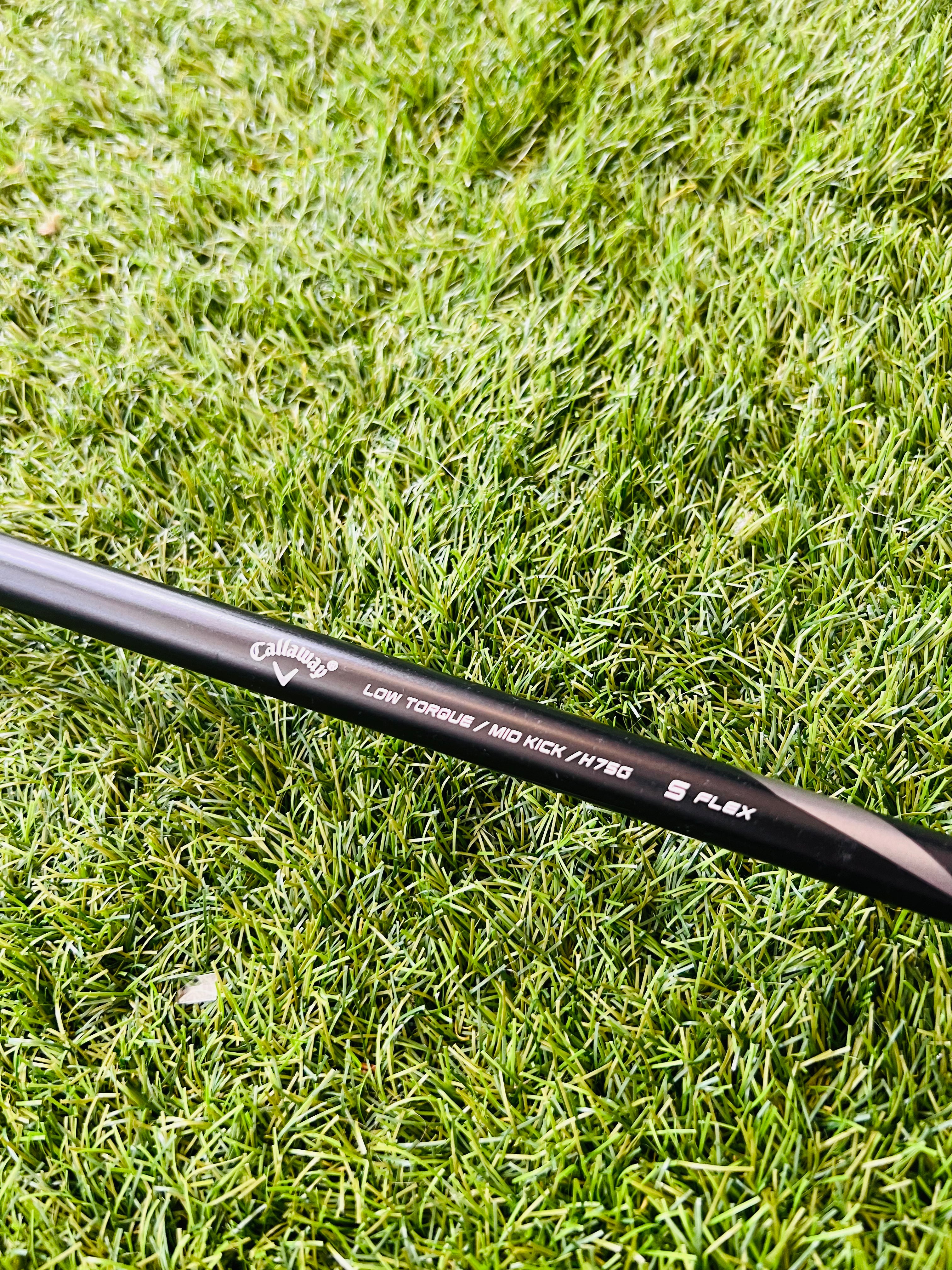 Rechtshandige Callaway RAZR X Tour hybride 2 (18°) golfclub met zwarte grip en titanium clubhoofd op golfbaan