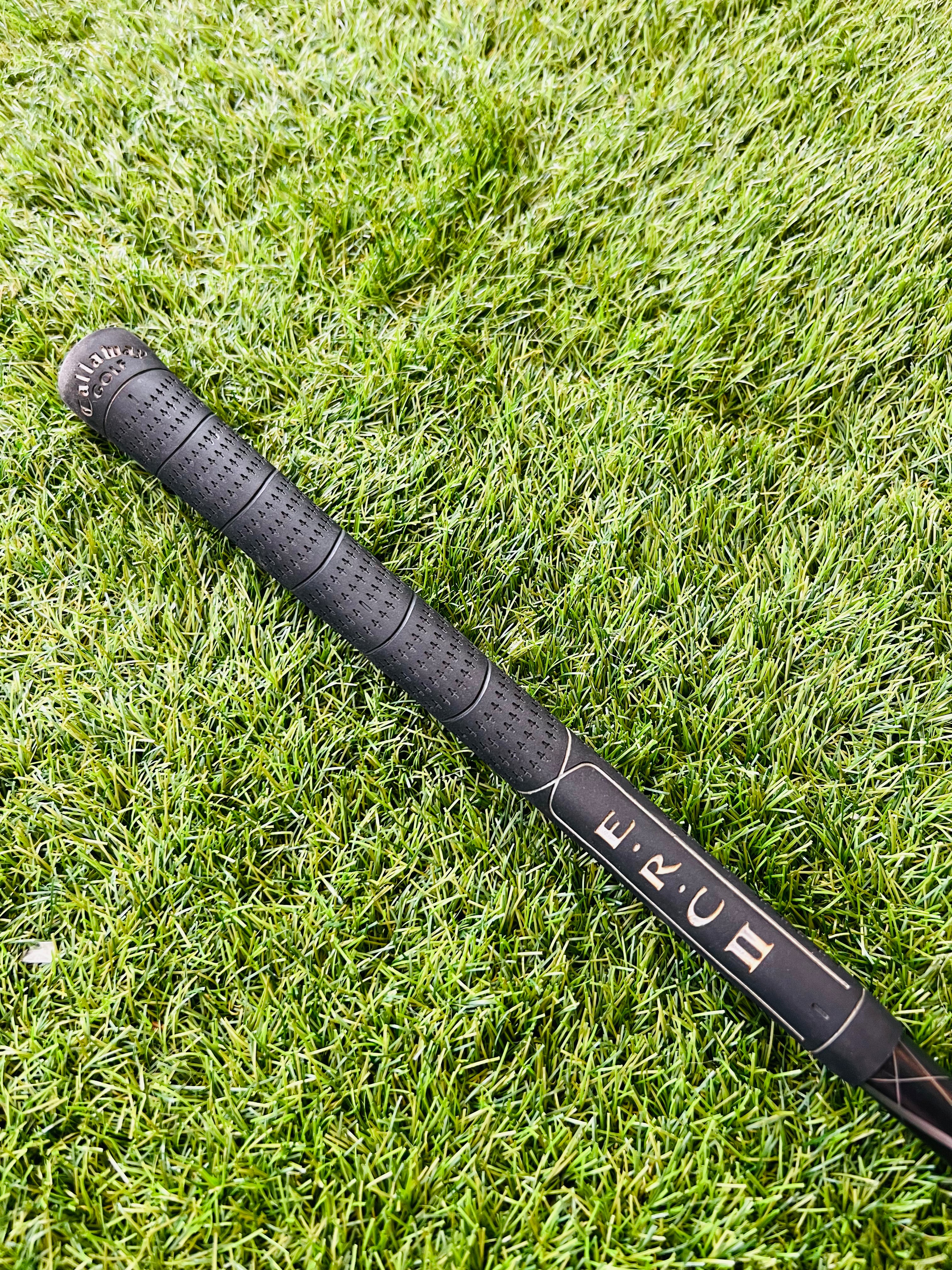 Rechtshandige Callaway RAZR X Tour hybride 2 (18°) golfclub met zwarte grip en clubhoofd op golfbaan voor heren