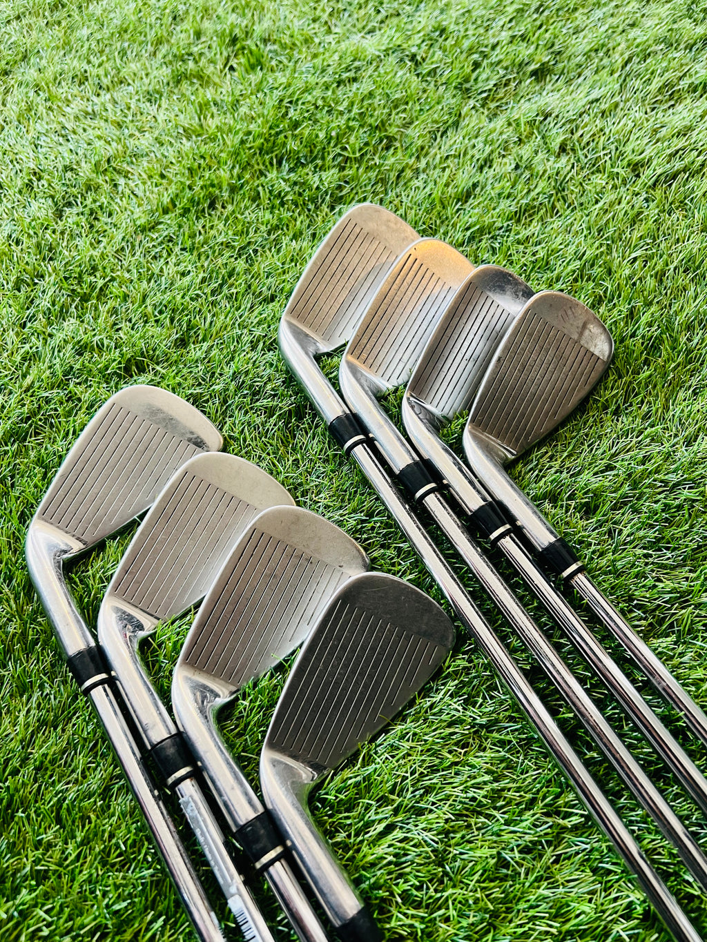 Rechtshandige Wilson Staff Ci9 golfclubs, ijzers 4 tot PW en gw, op een golfbaan met tee en golfballen.