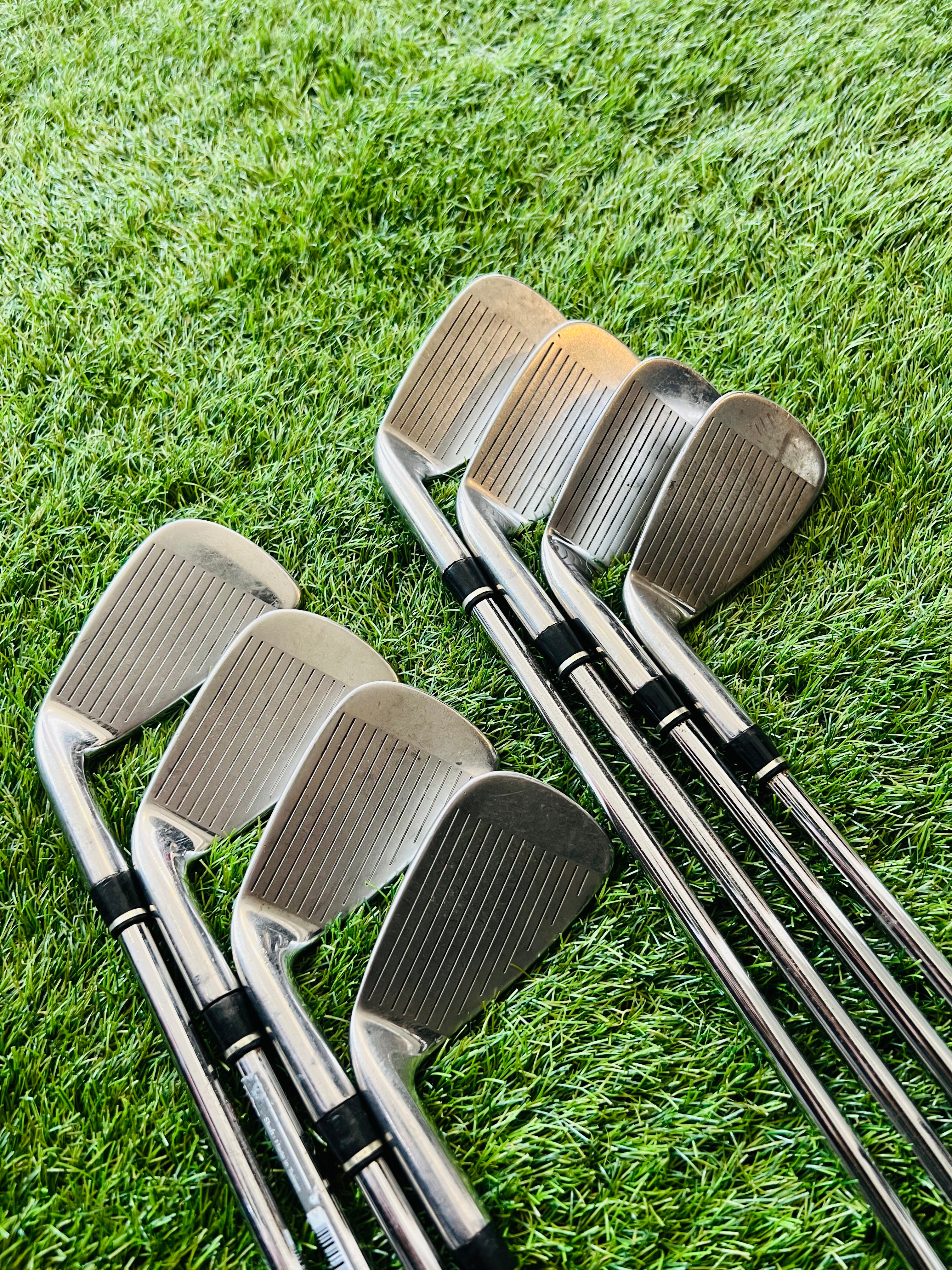 Rechtshandige Wilson Staff Ci9 golfclubs, ijzers 4 tot PW en gw, op een golfbaan met tee en golfballen.