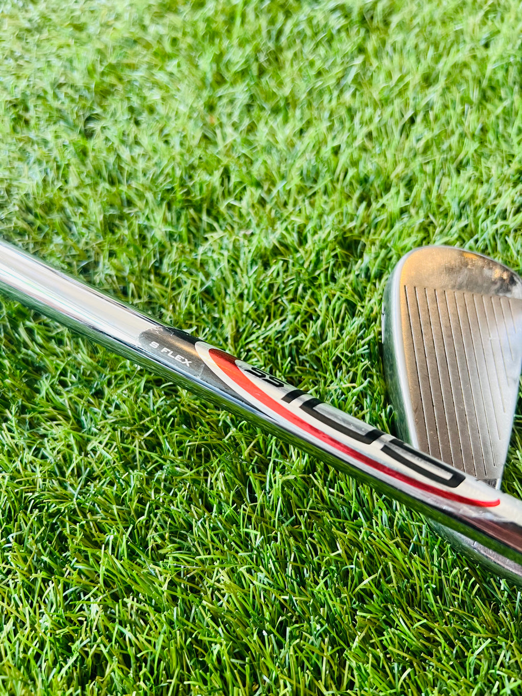 Rechtshandige Wilson Staff Ci9 golfclubs, ijzers 4 tot PW en wedge, liggend op een golfbaan, close-up van clubs en grips