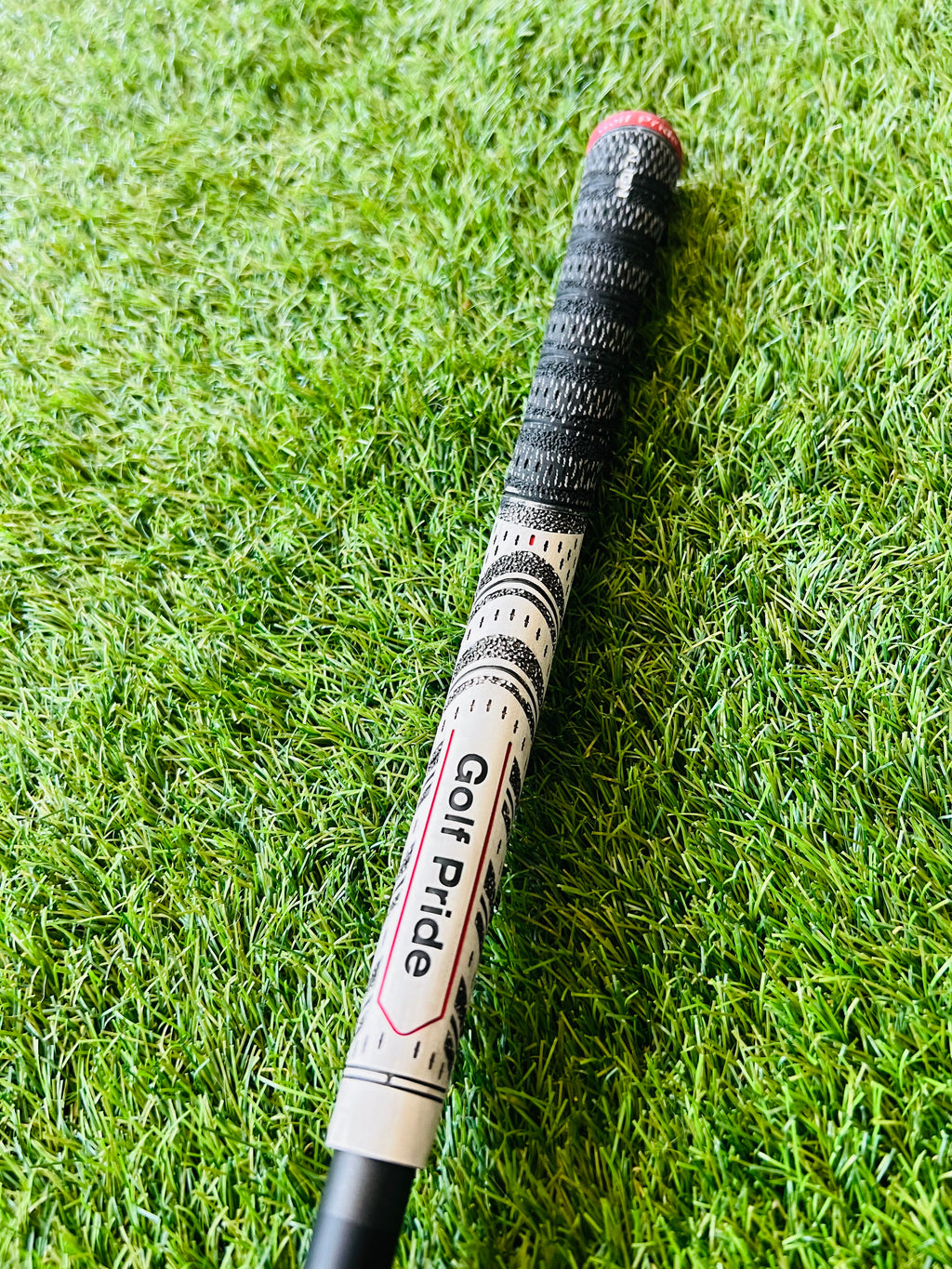 Callaway Rogue Cup 360 IJzerset 5 tot SW met +0.5 flex, inclusief clubs met graphite shafts en zwarte grips, op golfbaan.