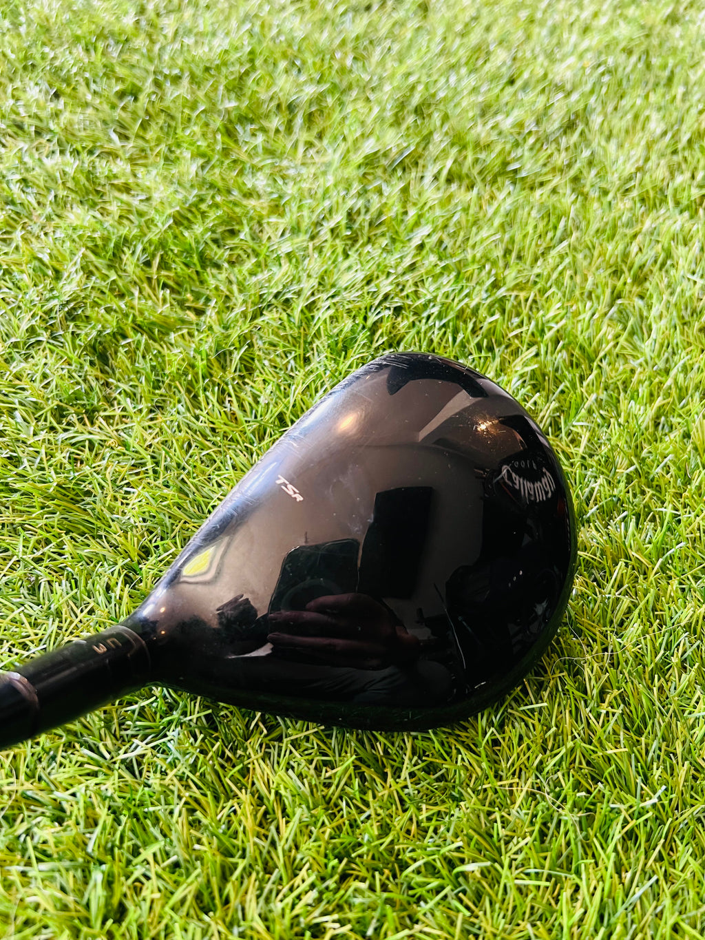 Titleist TSR3 fairwaywood 15° met hzrdus black stiff shaft, close-up van de clubkop en grip op de golfbaan