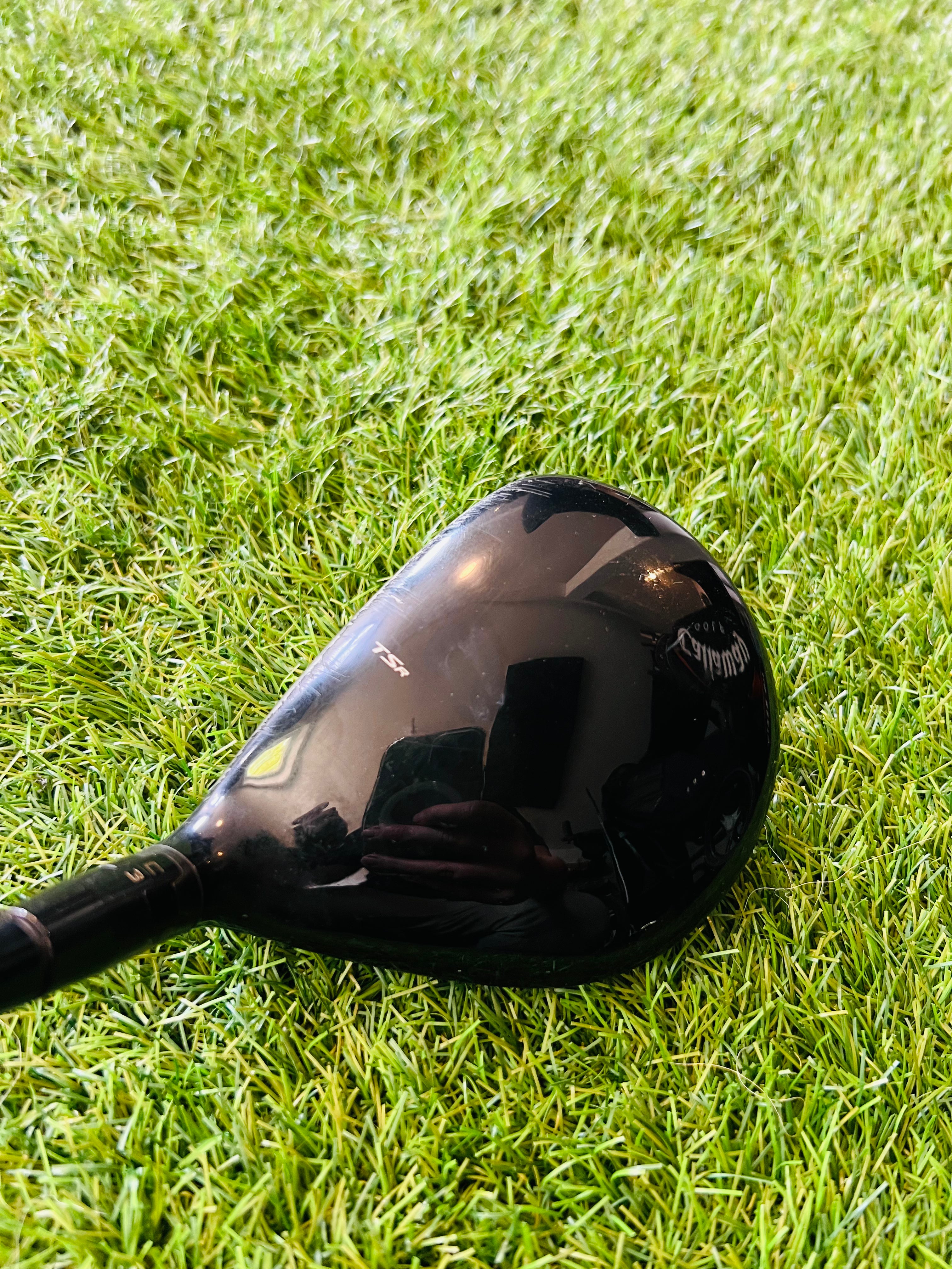 Titleist TSR3 fairwaywood 15° met hzrdus black stiff shaft, close-up van de clubkop en grip op de golfbaan