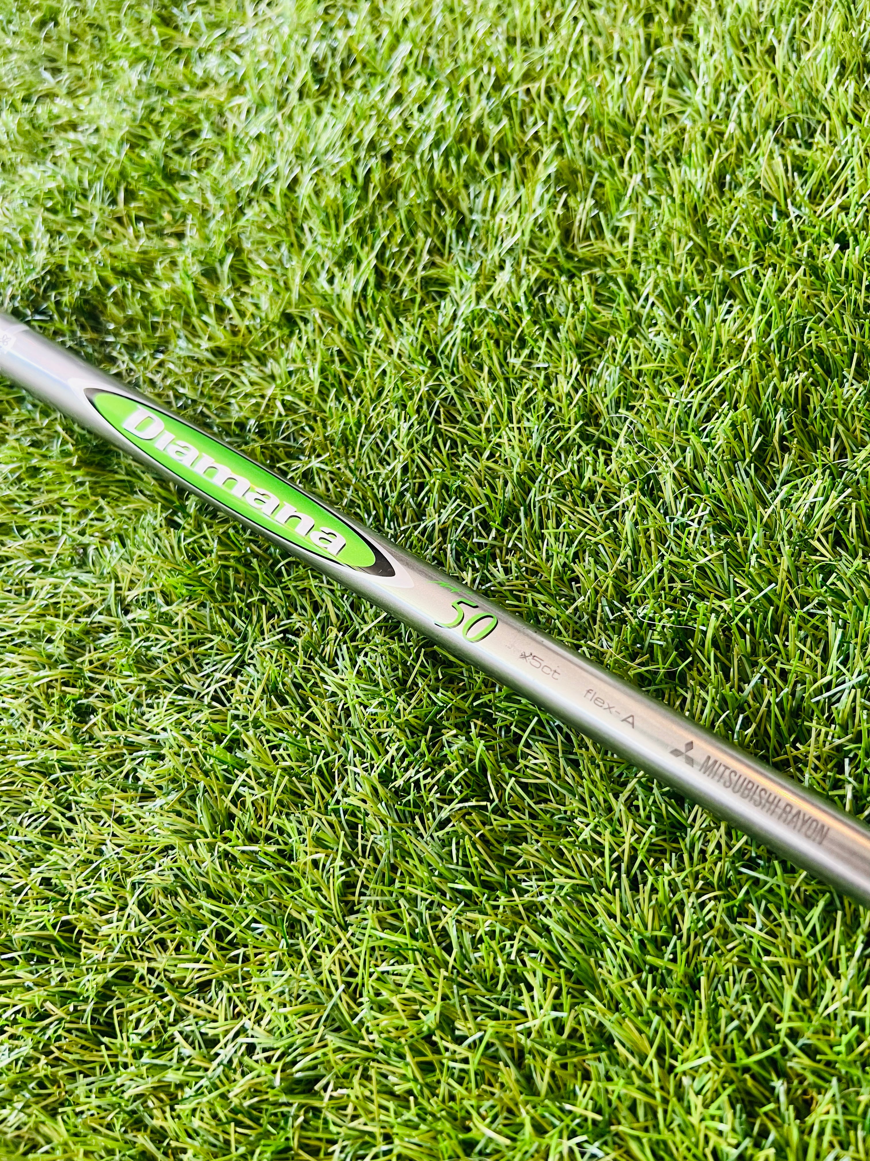 Callaway Epic Flash Fairwaywood 3 met 15° loft, rechtshandig, liggend op een golfbaan met clubs en golfballen op de achtergrond.