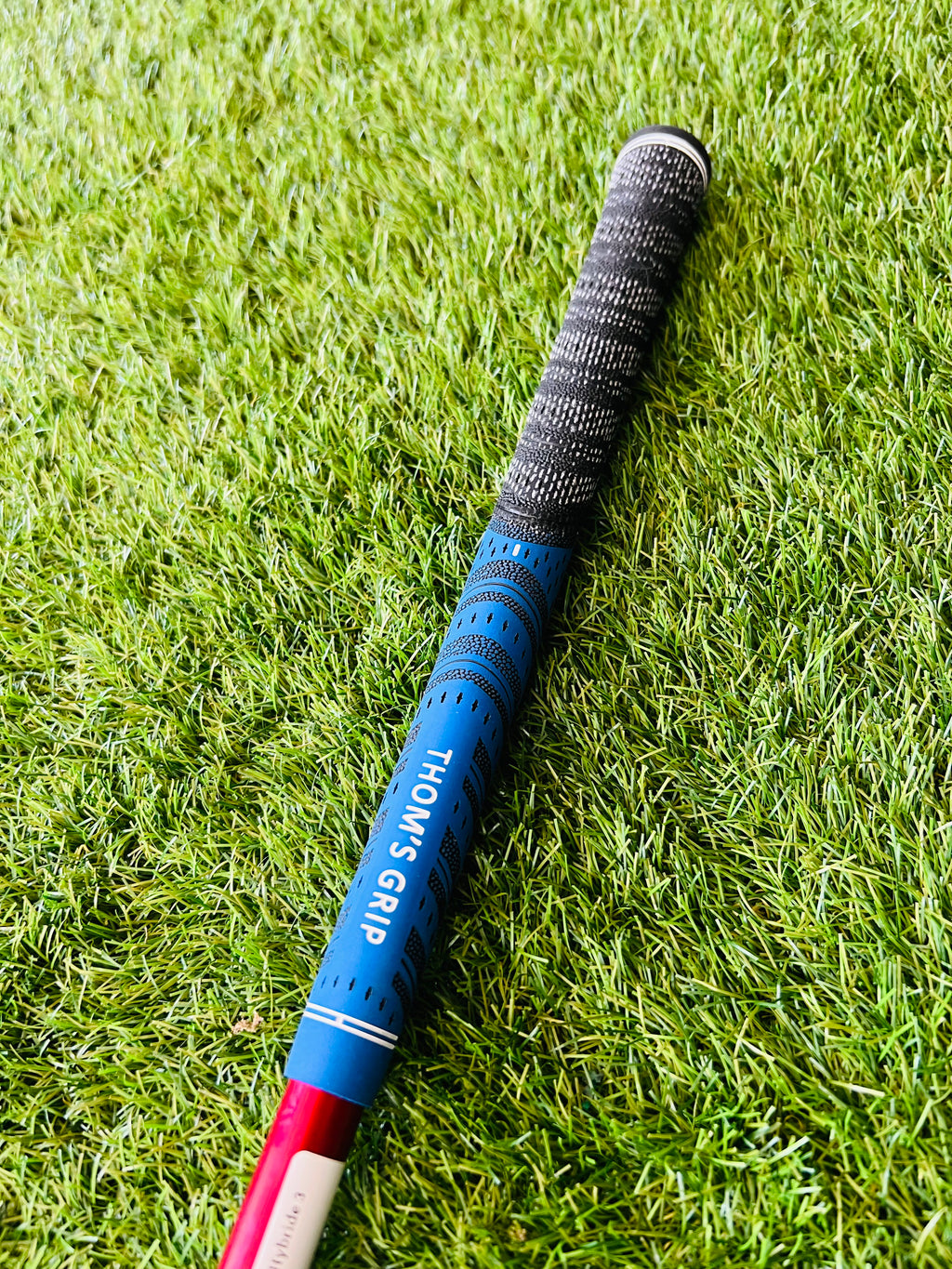 Wilson Dynapower Hybride 3 (19°) rechtshandig met graphite shaft, liggend op golfbaan met golfbal en clubs