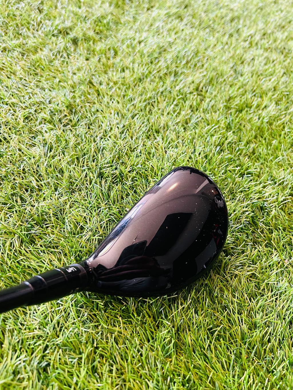 Titleist 915H hybride 2 met 18° loft, rechtshandig, zichtbaar met zwart handvat en golfclub head op een golfbaan.