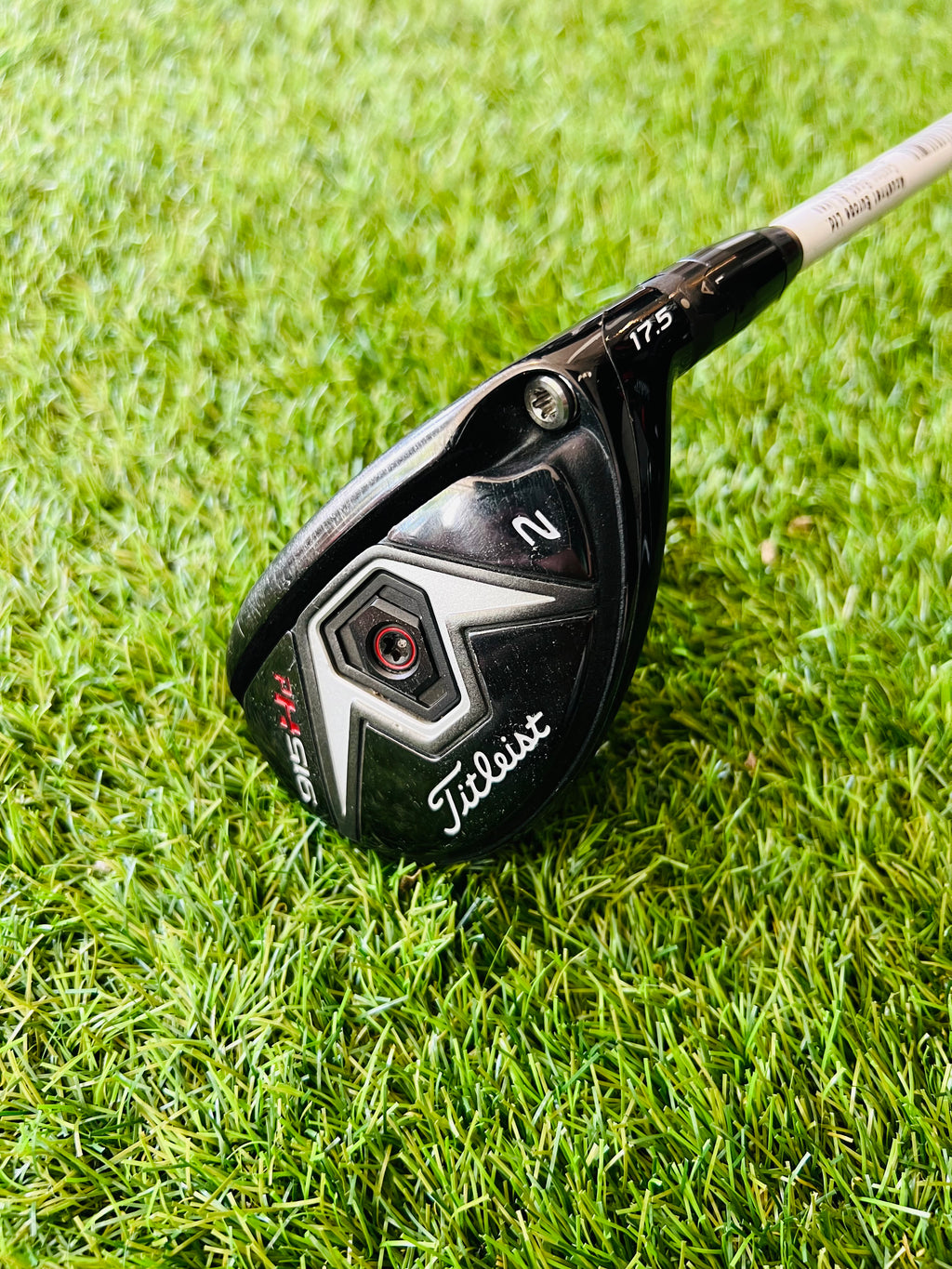 Titleist 915H hybride 2, 17,5°, rechtshandig, golfclub met graphite shaft en zwarte grip op houten achtergrond