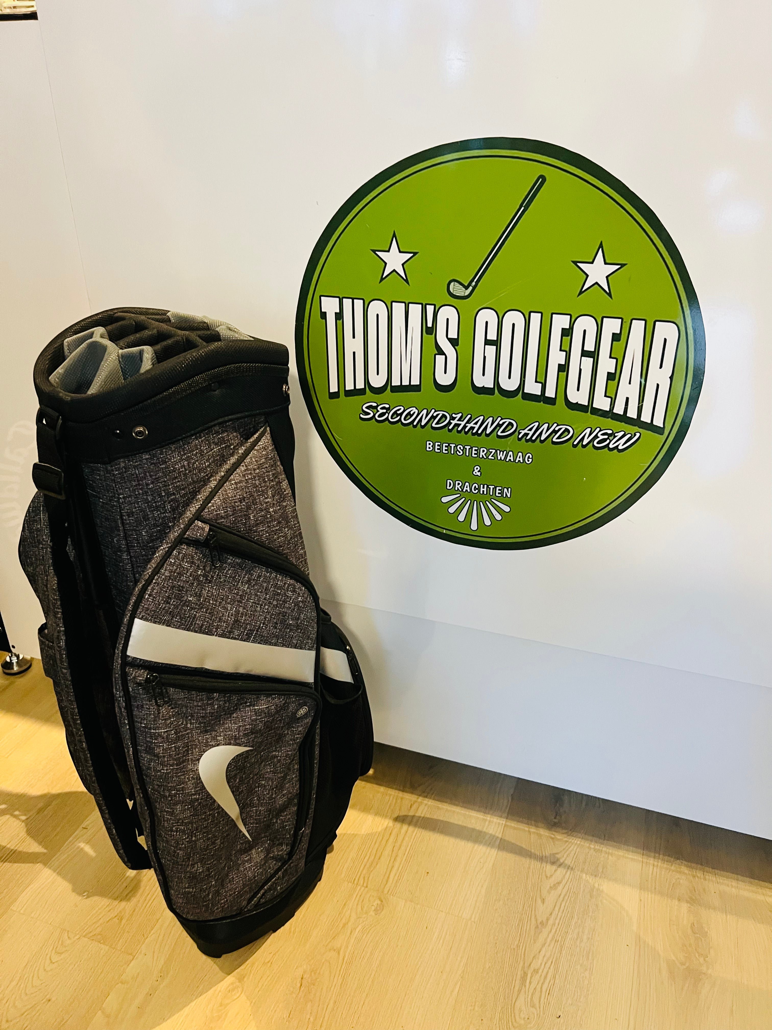 Zwarte en grijze Nike golfcartbag met 14 vakken en regenhoes, geschikt voor golfclubs en accessoires.