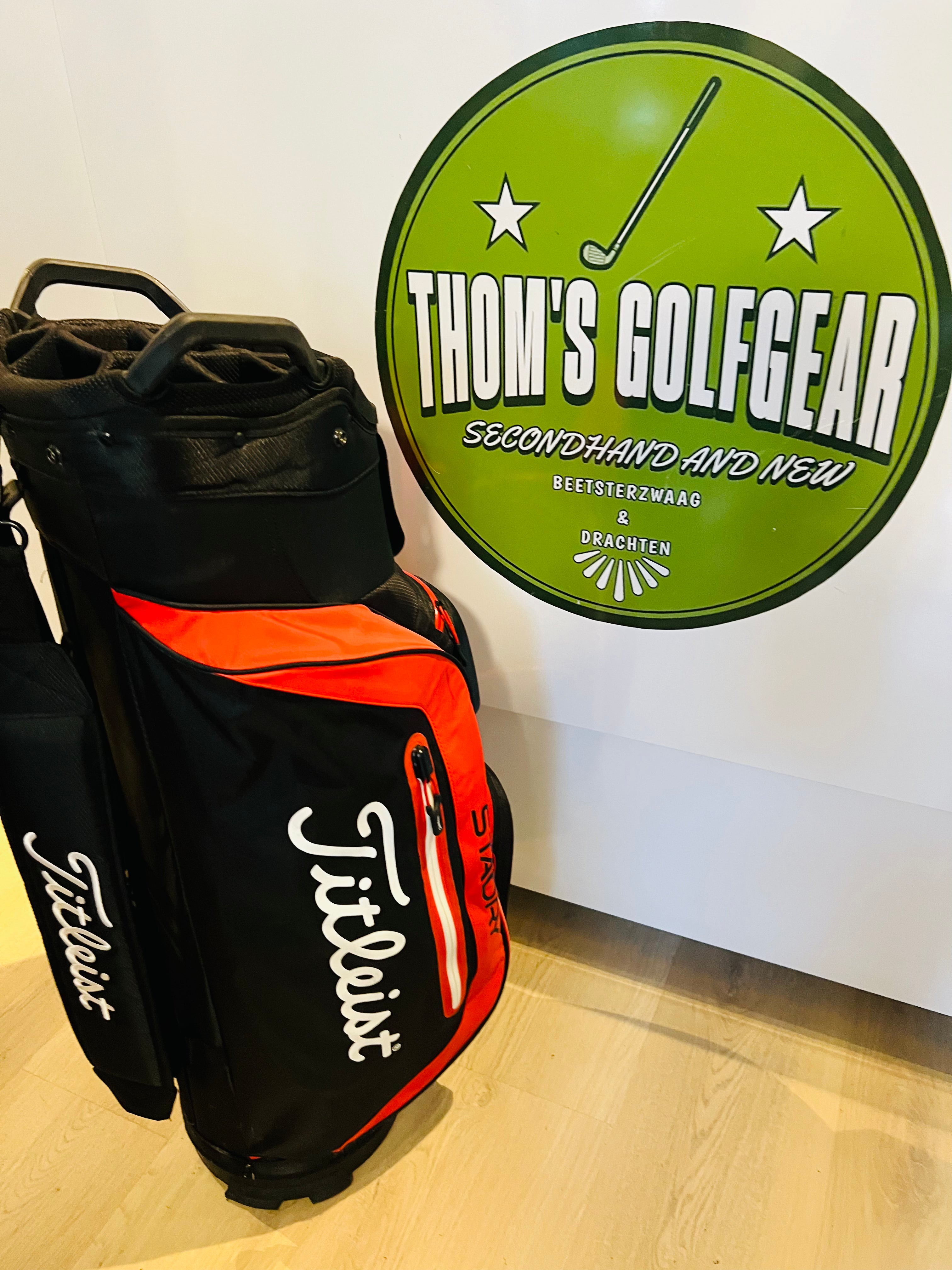 Rode en zwarte Titleist StaDry golfcarttas met meerdere vakken en handvatten, geschikt voor golfclubs en accessoires.