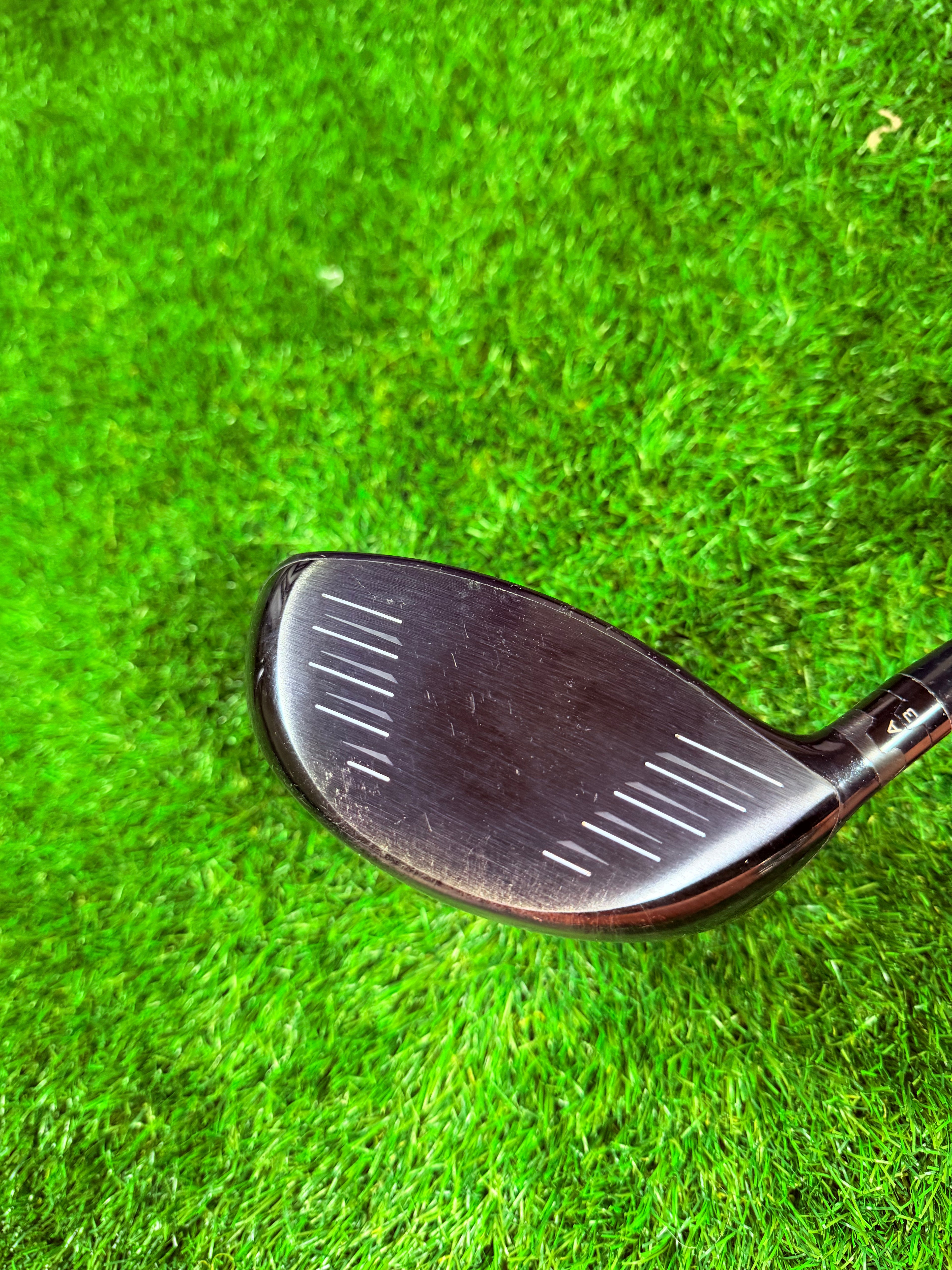 Rechtshandige Titleist 915D3 driver met 9,5° loft, golfclub met zwart grip en titanium clubhoofd, liggend op een houten vloer