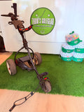 Elektrische Golftrolley Motocaddy S1 Pro van Thom's Golfgear op golfbaan met handvat en display.