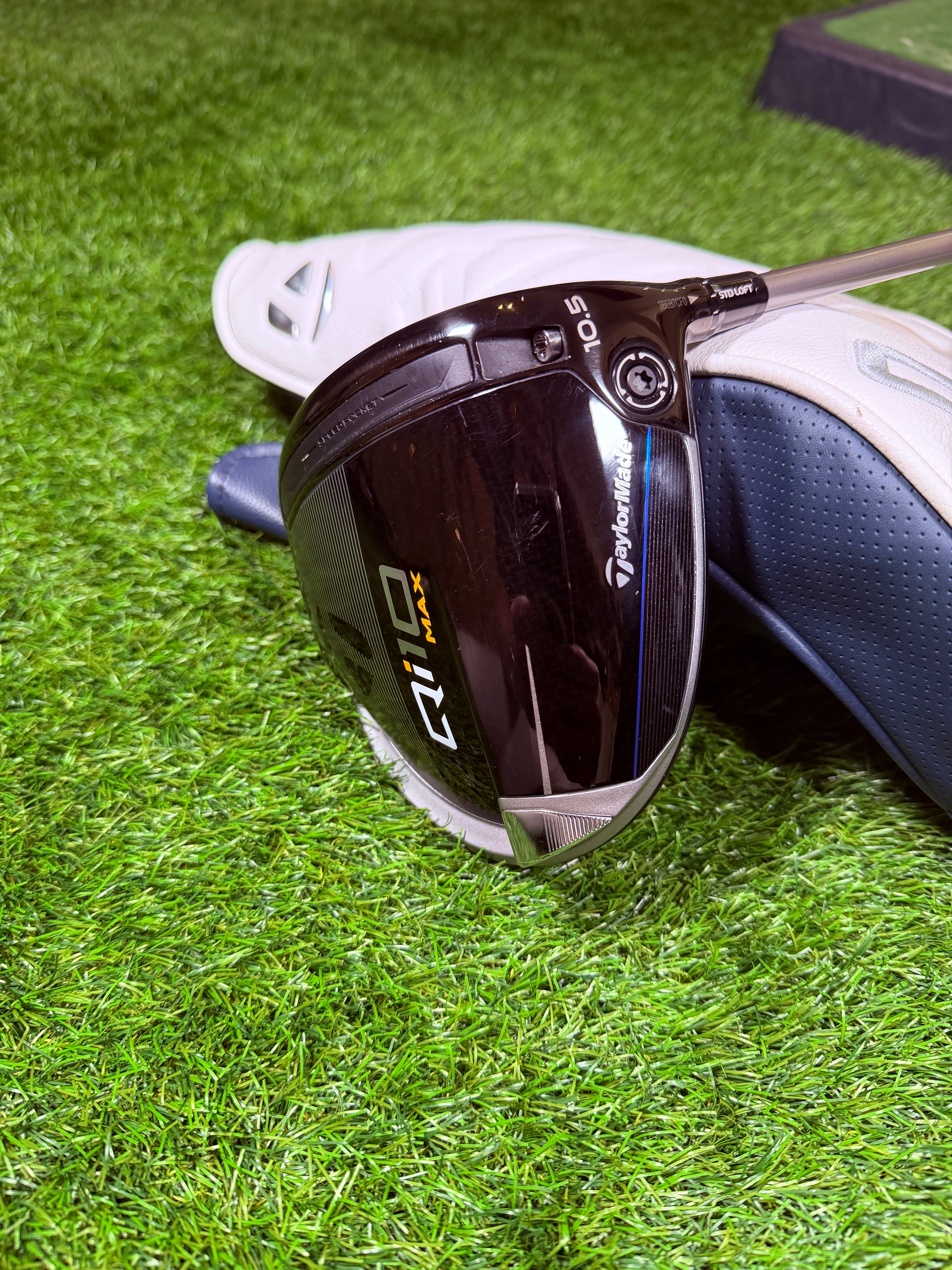 Rechtshandige TaylorMade Qi10 Max golfdriver met 10,5° loft, zichtbaar op een golfbaan, met blauwe en zwarte details.