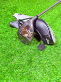 TaylorMade Qi35 Max hybride 6 (31°) voor rechtshandige golfers, liggend op een golfbaan met golfclubs op de achtergrond.