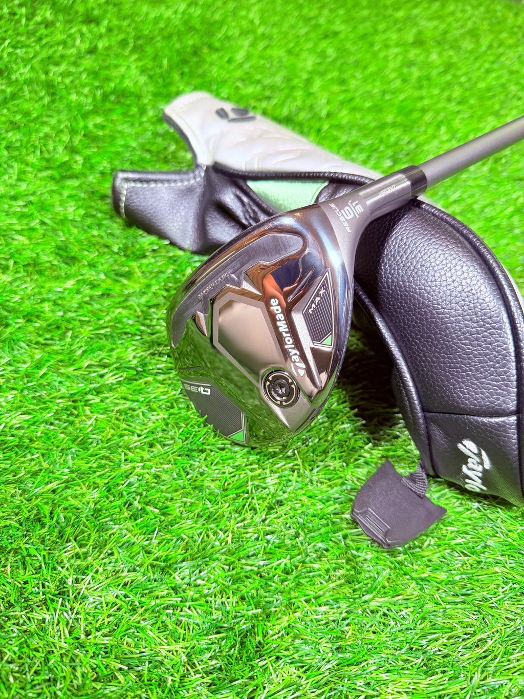 Rechtshandige TaylorMade Qi35 Max hybride 6 (31°) golfclub met graphite shaft, zichtbaar in close-up, liggend op gras.
