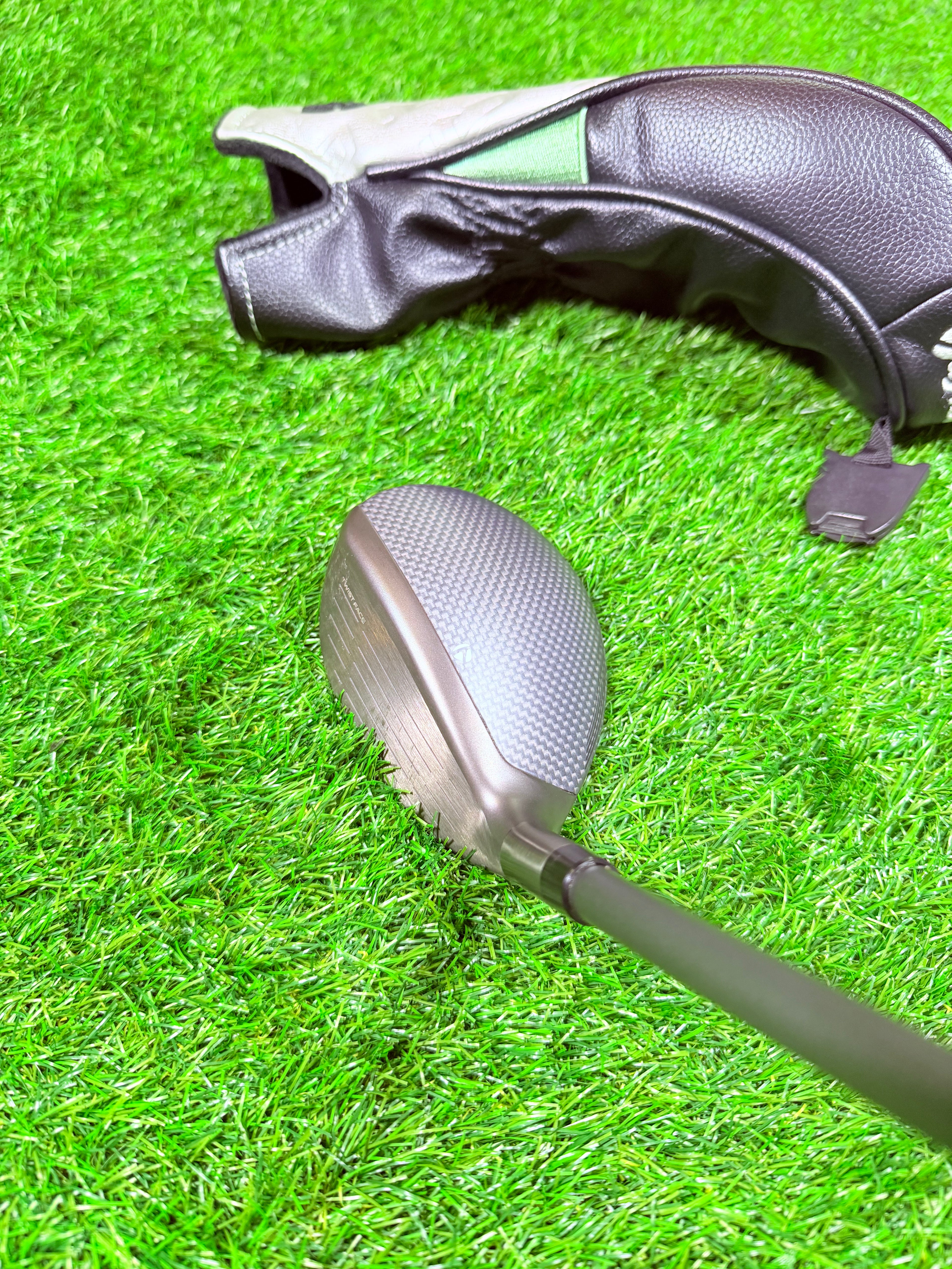 Rechtshandige TaylorMade Qi35 Max hybride 6 (31°) golfclub, zichtbaar met grip en clubhoofd op een golfbaan.
