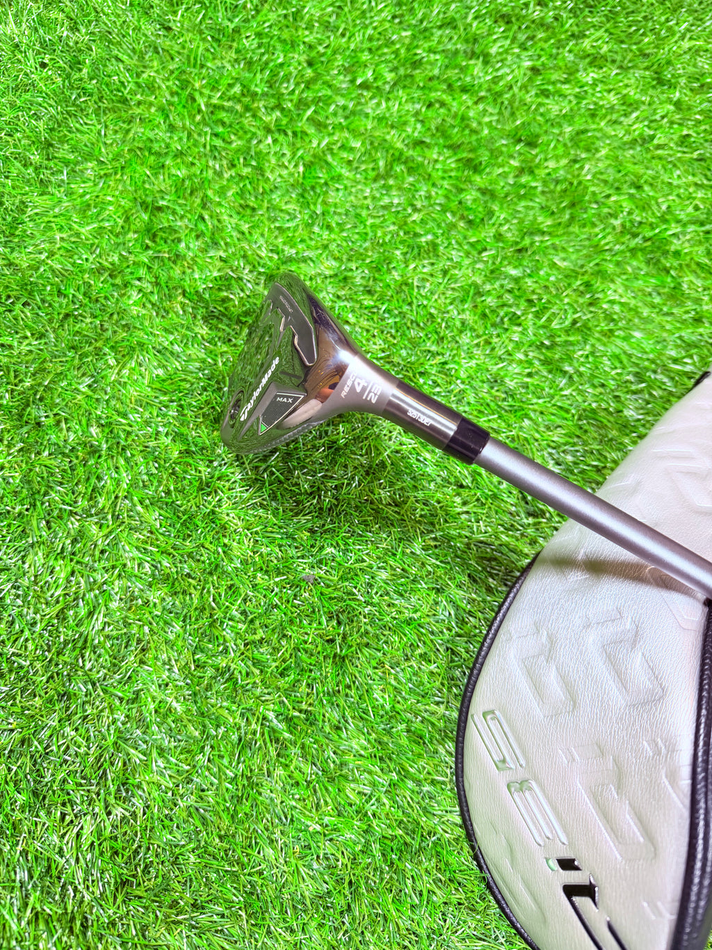 Hybride golfclub TaylorMade Qi35 Max 4 23° rechtshandig, zichtbaar met grip en clubkop op een golfbaan