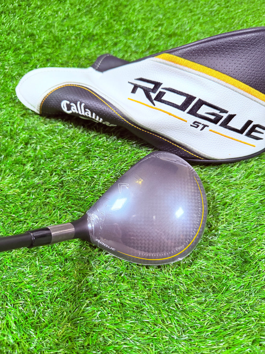 Luchtfoto van een Callaway Rogue ST Max D 5-wood golfclub met 19° loft, liggend op een grasveld.