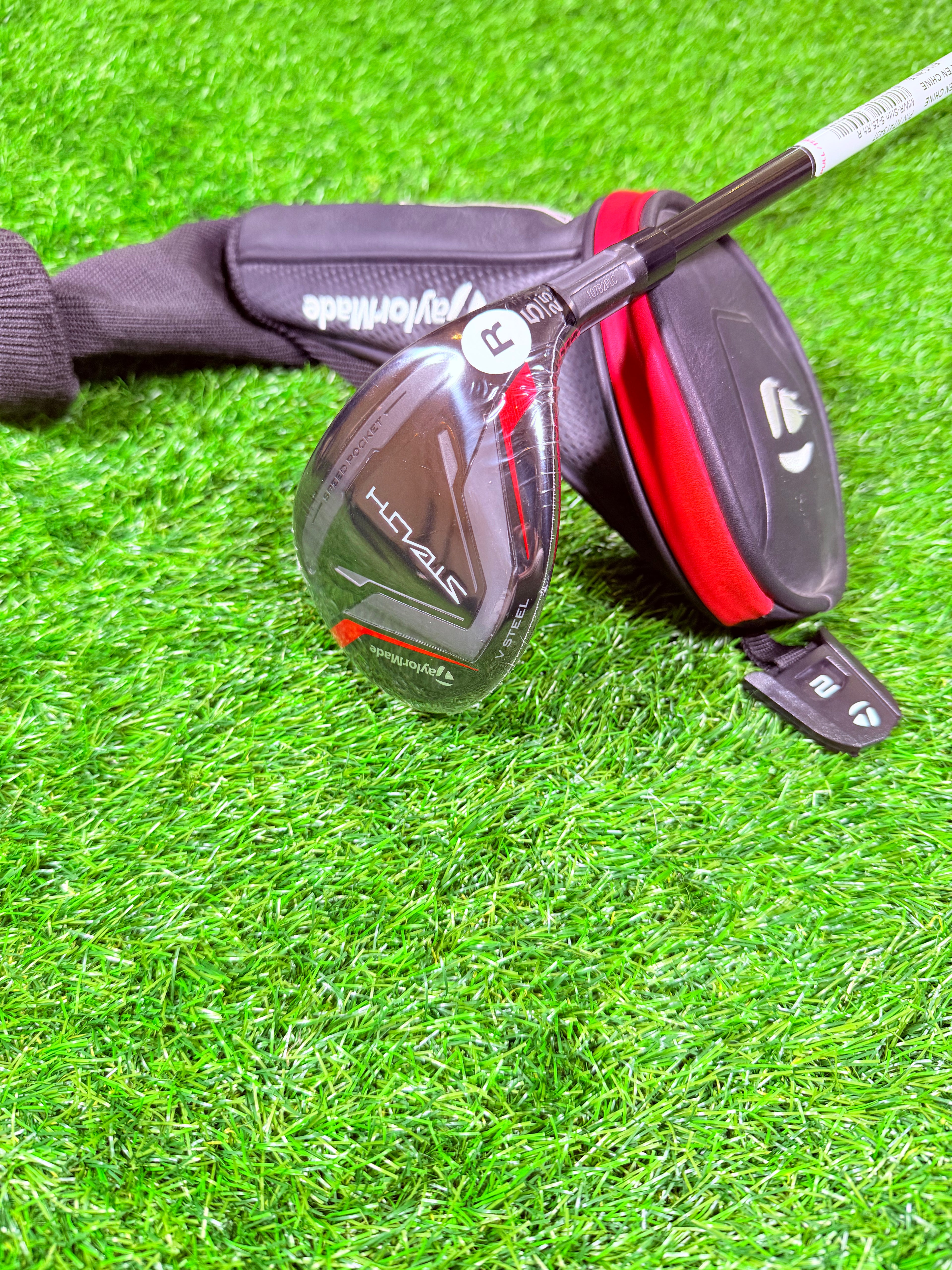 TaylorMade Stealth Hybride 5 (25°) golfclub op een golfbaan, zichtbaar met grip en clubhoofd in close-up.
