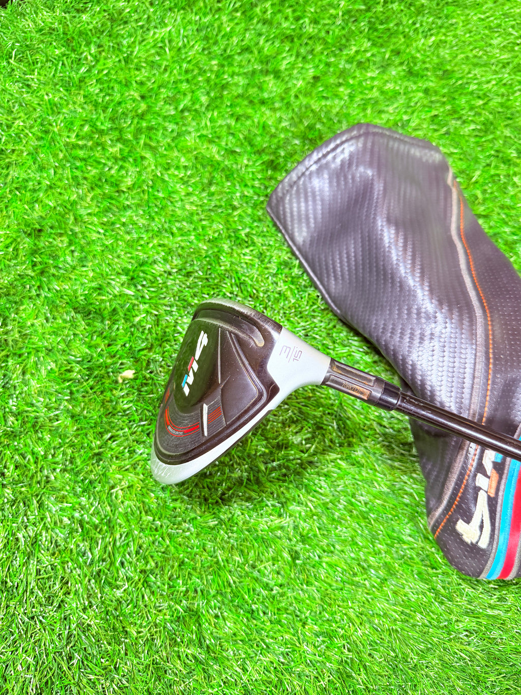 Rechtshandige TaylorMade M4 3-wood (15°) golfclub, liggend op een groene golfbaan, klaar voor gebruik.