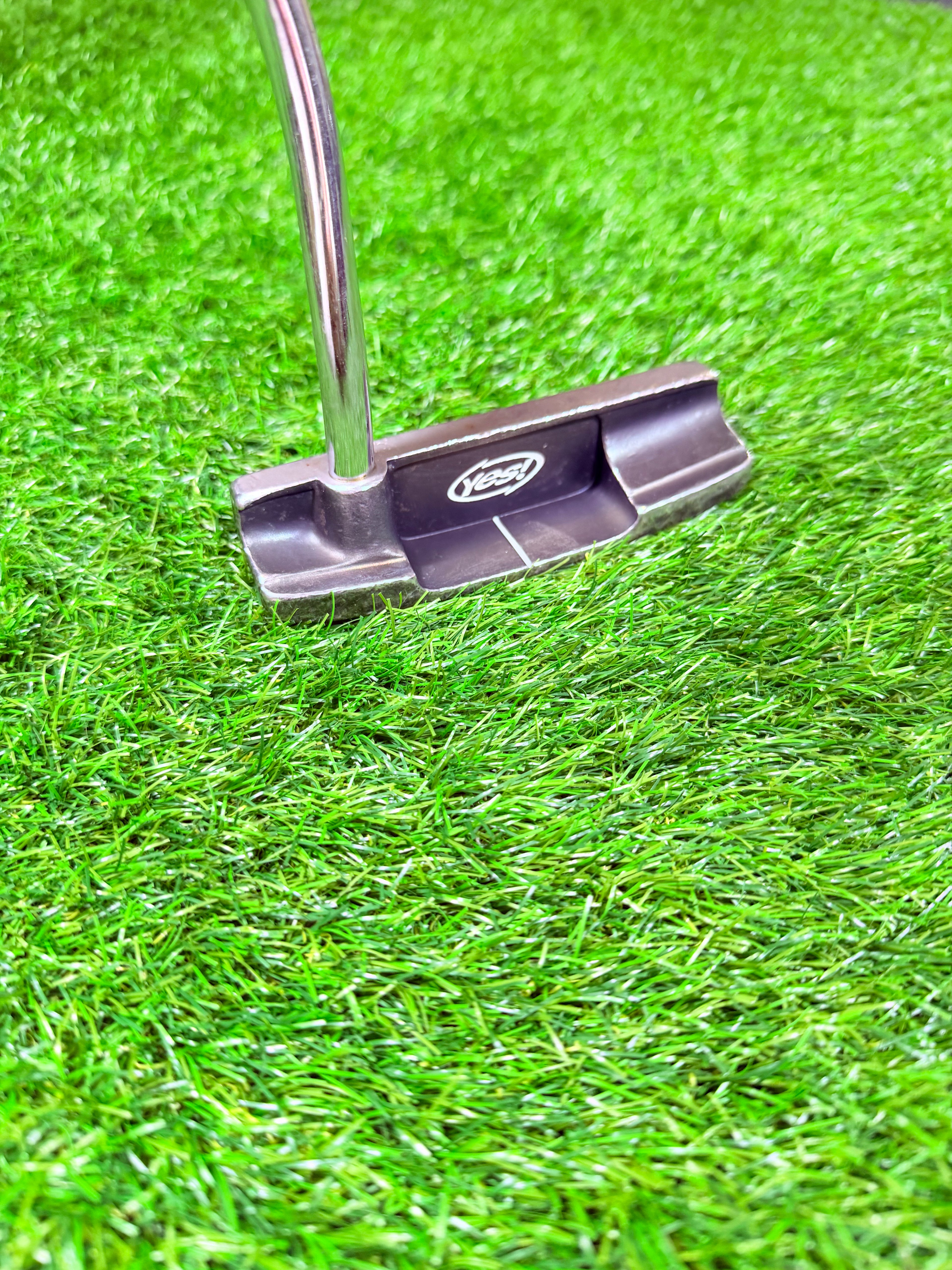 Rechtshandige YES! C-Groove Tracy Putter van Thom's Golfgear, 35 inch, ligt comfortabel op een golfbaan.