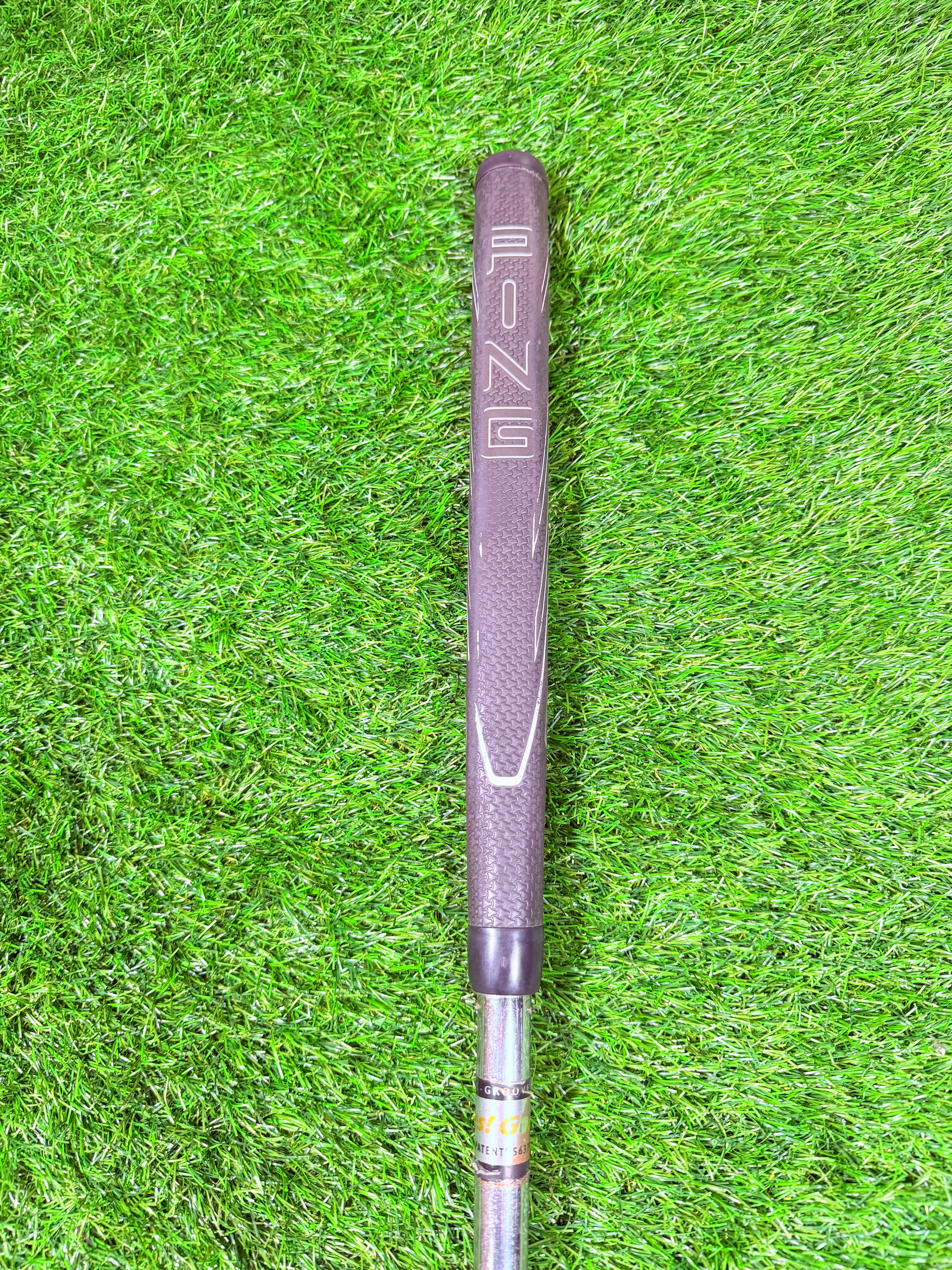 Rechtshandige YES! C-Groove Tracy Putter van Thom's Golfgear, 35 inch, gelegen op een golfbaan met een bal en putting mat.