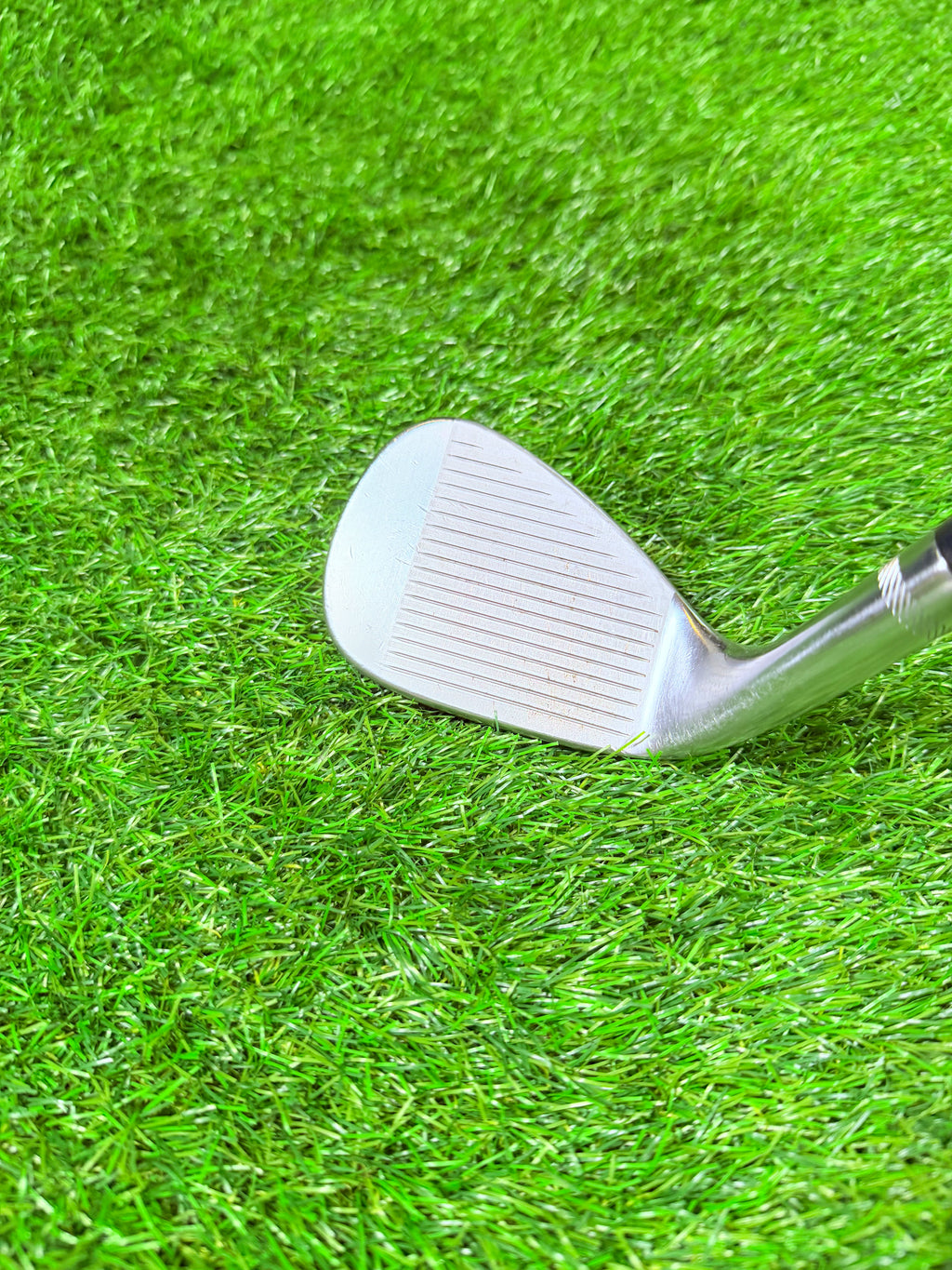 Rechtshandige Titleist Vokey Design SM7 wedge 52° met 12° F Grind, close-up van de clubkop op golfbaan