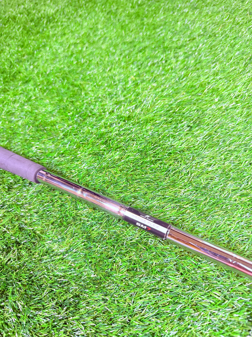 Titelist Vokey SM7 52° wedge met 12° F grind, rechtshandig, golfclub met zwarte afwerking en grip op de afbeelding