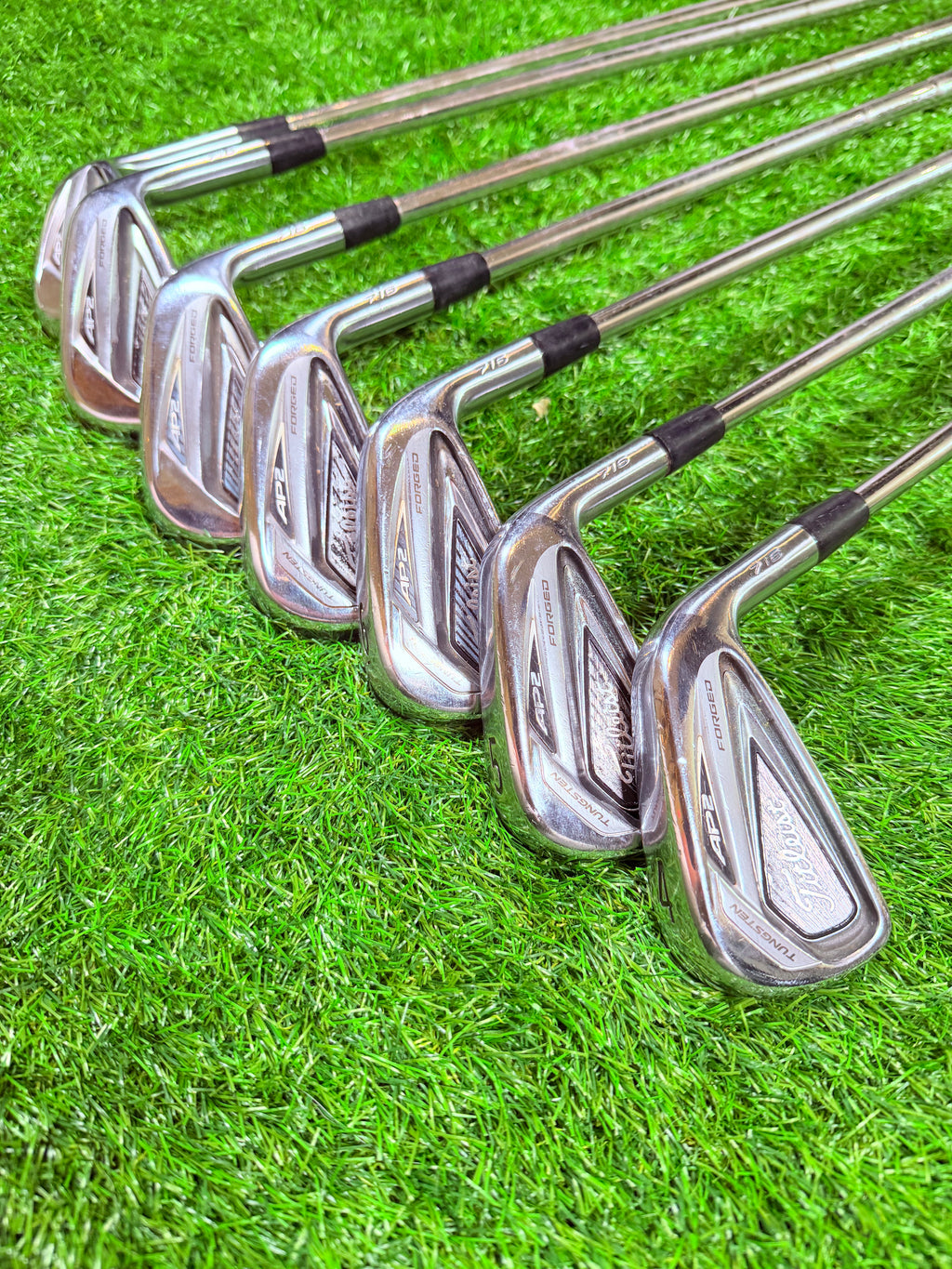 Titleist AP2 716 ijzerset 4 tot en met PW, rechtshandig, golfclubs zichtbaar met houten handgrepen en clubkoppen.