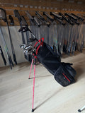 Cobra AIR-X dames golfset met 6 tot PW, hybride 5, 5-wood, putter en standbag, liggend op een golfbaan.