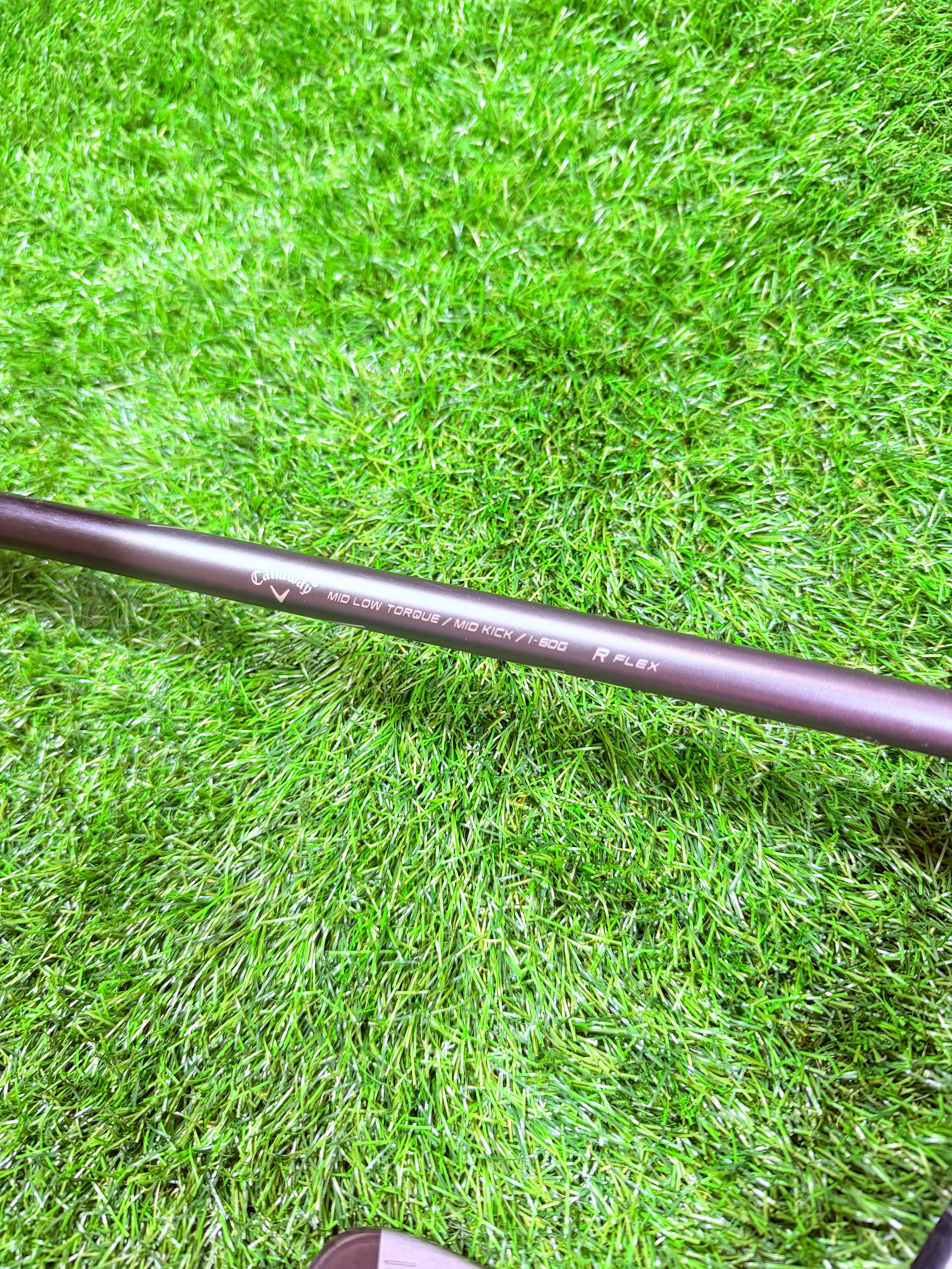 Verschillende Callaway RAZR XF ijzers 5 tot PW in graphite, rechtshandig, voor golfspelers, liggend op een golfbaan.