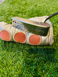 Scotty Cameron Studio Style Newport 1.5 putter, 34 inch, met houten handgreep en geborsteld zilveren afwerking, liggend op golfbaan