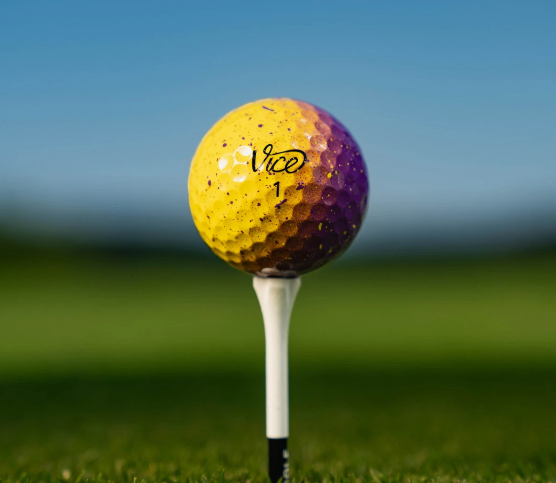 Twaalf Thom's Golfgear Vice Pro Royal Gold golfballen in een doos, met gele en blauwe branding en logo op de ballen